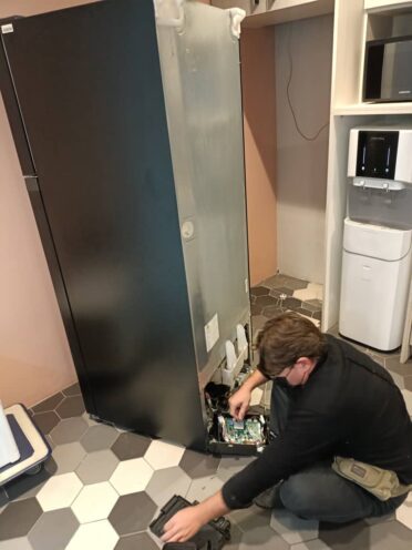 Refrigerator Repair 21 Close-up of a technician replacing the door seal of a refrigerator to improve energy efficiency.