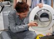 A technician inspecting and repairing a dryer, ensuring it functions properly and efficiently.