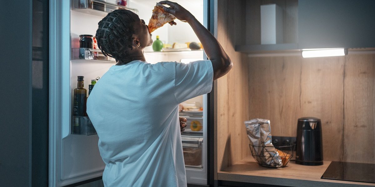 An open refrigerator displaying neatly organized shelves filled with fresh produce, beverages, and other groceries.
