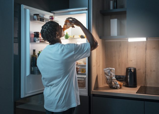 An open refrigerator displaying neatly organized shelves filled with fresh produce, beverages, and other groceries.