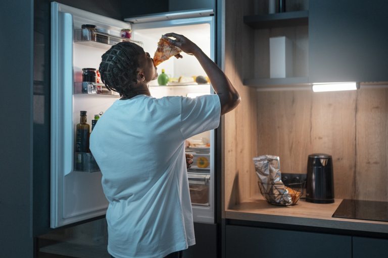 An open refrigerator displaying neatly organized shelves filled with fresh produce, beverages, and other groceries.